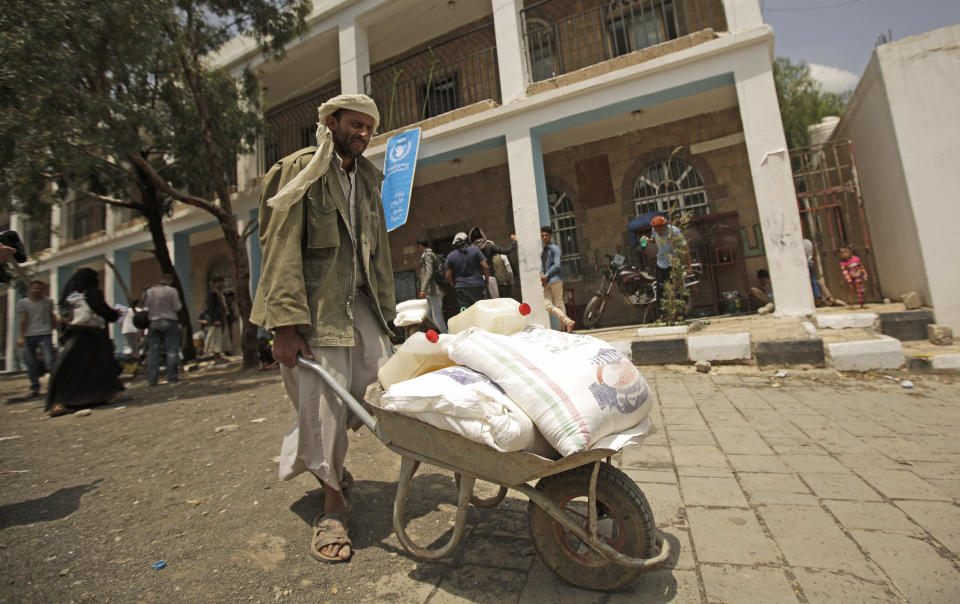 FILE - In this Aug. 25, 2019 file photo, a displaced Yemeni receives food aid provided by the World Food Program, at a school in Sanaa, Yemen. The World Food Program won the Nobel Peace Prize on Friday, Oct. 9, 2020 for its efforts to combat hunger amid the coronavirus pandemic, recognition that shines light on vulnerable communities across the Middle East and Africa that the U.N. agency seeks to help, those starving and living in war zones that may rarely get the world’s attention.(AP Photo/Hani Mohammed)