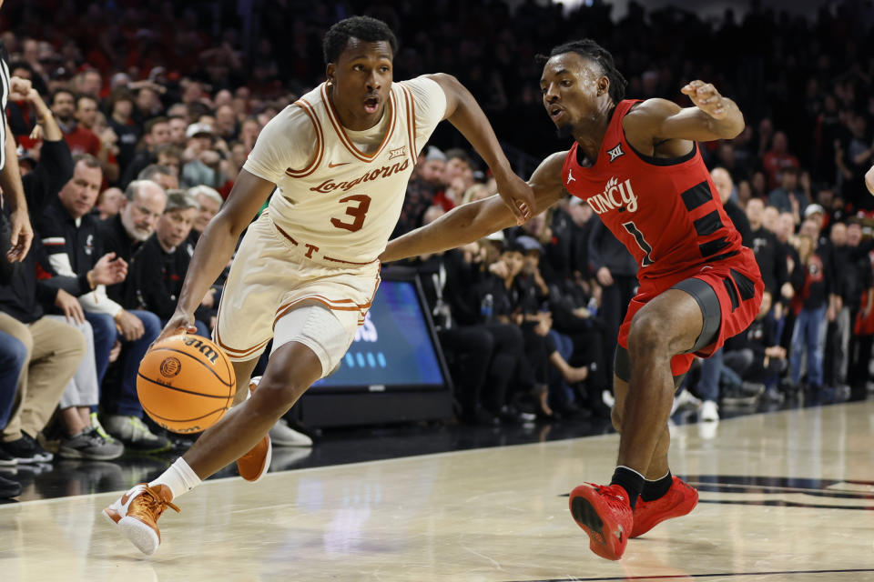 Texas' Max Abmas, left, drives to the basket against Cincinnati's Day Day Thomas during the second half of an NCAA college basketball game Tuesday, Jan. 9, 2024, in Cincinnati. (AP Photo/Jay LaPrete)