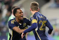 Vancouver Whitecaps midfielder Ryan Gauld (25) celebrates his goal against the Seattle Sounders with forward Ali Ahmed, left, during the second half of an MLS soccer match Saturday, April 20, 2024, in Seattle. (AP Photo/Lindsey Wasson)