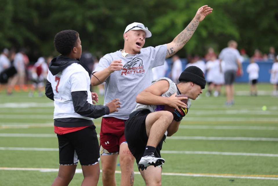 South Carolina quarterback Spencer Rattler works with kids attending the Spencer Rattler FlexWork Football Camp at Dreher High School in Columbia on Saturday, May 20, 2023.