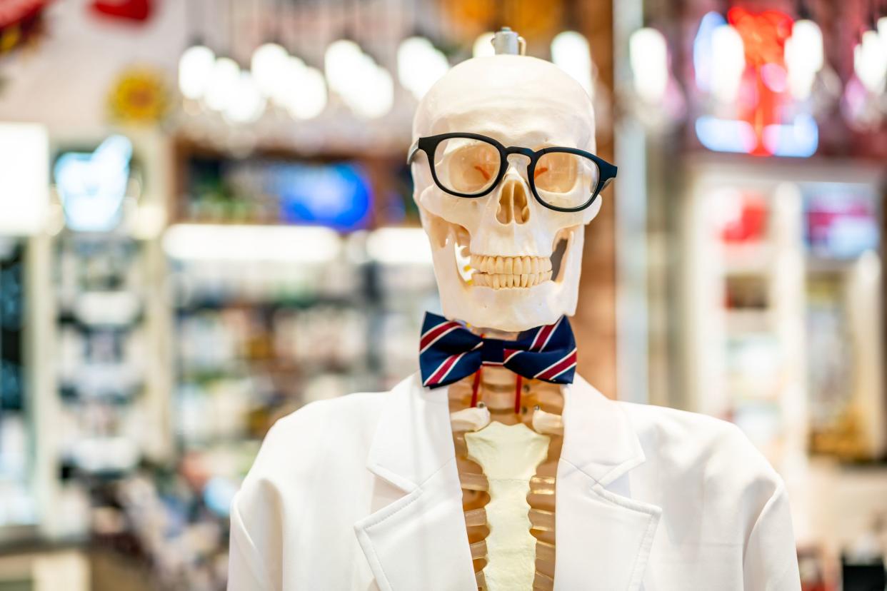 A skeleton model wearing white clothes and black glasses