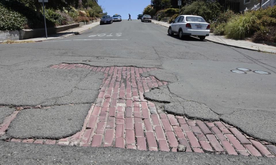 In this photo taken Thursday, July 19, 2012, cobblestones show through a hole in the pavement on Sutter Street in Vallejo, Calif. In 2008 Vallejo declared bankruptcy, forcing the reduction of many city services, like road repairs. Emerging from bankruptcy last year, the Vallejo offers an example for what can come, both good and bad, from the experience. Some in the community say bankruptcy was the city's only option to climb out of a financial hole while others say more could have been done to avoid it.(AP Photo/Rich Pedroncelli)