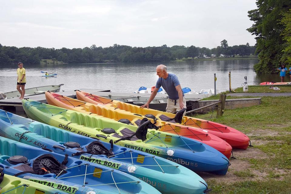 Will Stahlman of Greenway Outdoors adjusts a kayak at Memorial Lake State Park where his company rents various types of watercraft.