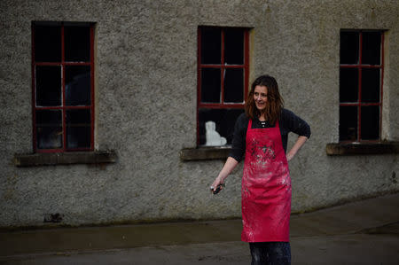 Potter Brenda McGinn stands outside her studio, the former Jas Boylan shoe factory which was the main employer in the area until it shut down due to The Troubles, in Mullan, Ireland, March 16, 2018. "When I came back, this would have been somewhere you would have driven through and have been quite sad. It was a decrepit looking village," said McGinn, whose Busy Bee Ceramics is one of a handful of enterprises restoring life to the community. "Now this is a revitalised, old hidden village." REUTERS/Clodagh Kilcoyne