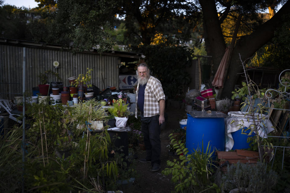 Joel Schaegis, 56, French army veteran a supermarket employee works in his small elevated farm in a northern neighbourhood of Marseille, southern France, Tuesday, Oct. 26, 2021. Joel Schaegis tends to what he refers to as his "little paradise," the roughly 50 square meters of hillside land that he has made his garden. (AP Photo/Daniel Cole)