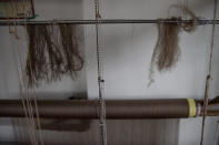 Pashmina threads hang on a loom in Srinagar, Indian controlled Kashmir, Saturday, June 13, 2020. A months-long military standoff between India and China has taken a dire toll on local communities as tens of thousands of Himalayan goat kids die because they couldn't reach traditional winter grazing lands, officials and residents said. Nomads have roamed these lands atop the roof of the world for centuries, herding the famed and hardy goats that produce the ultra-soft wool known as Pashmina, the finest of cashmeres. Cashmere takes its name from the disputed Kashmir valley, where artisans weave the wool into fine yarn and exquisite shawls that cost up to $1,000 apiece in world fashion capitals in a major handicraft export industry that employs thousands. (AP Photo/Dar Yasin)