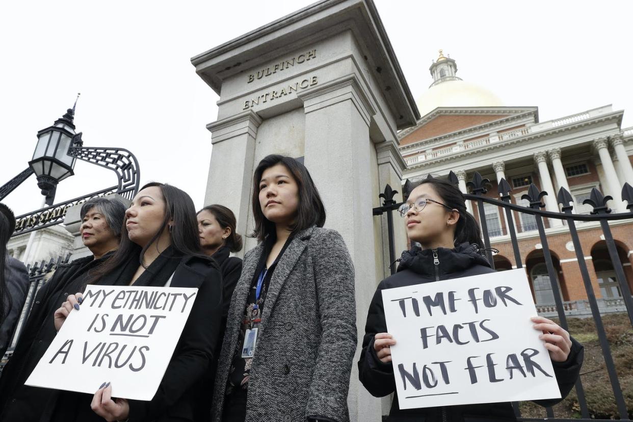 <span class="caption">Members of the Massachusetts Asian American Commission protest on the steps of the Statehouse in Boston.</span> <span class="attribution"><span class="source">AP Photo/Steven Senne</span></span>