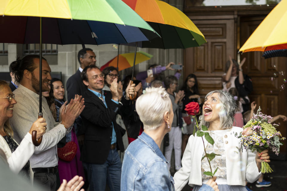 Annett Babinsky, center,, and Laura Suarez celebrate their marriage at the registry office 'Amtshaus' in Zurich, Switzerland, Friday, July 1, 2022. After a yes vote in the "Marriage for All" vote last fall, from July 1, same-sex couples marriage for the first time in Switzerland. (Ennio Leanza/Keystone via AP)