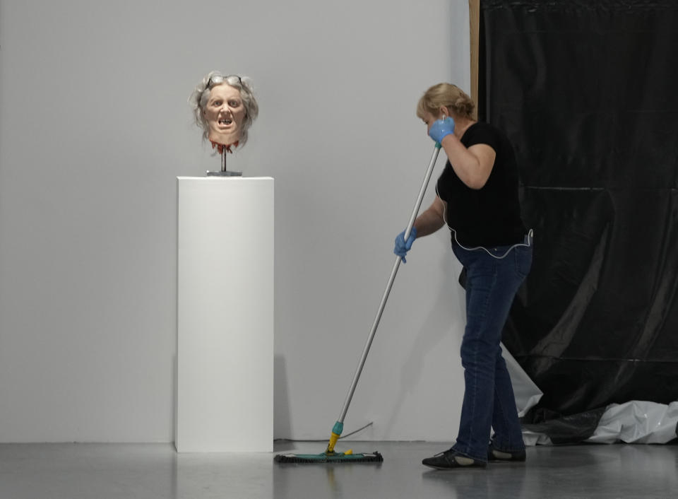 A worker cleans near an exhibit by Danish conceptual artist Kristian von Hornsleth at the Ujazdowski Castle Center for Contemporary Art in Warsaw, Poland, Wednesday Aug. 25, 2021. The exhibition which opens Friday at the Polish state museum features the works of provocative artists in what organizers describe as a celebration of free speech, and a challenge to political correctness and "cancel culture" on the political left. Some critics, however, accuse the organizers of the show titled "Political Art" of giving a platform to anti-Semitic, racist and Islamophobic messages. (AP Photo/Czarek Sokolowski)