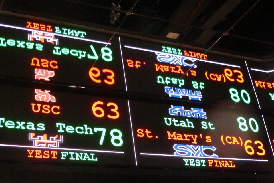 In this Nov. 20, 2018 photo a scrolling video board with basketball scores is reflected in the ceiling of a sportsbook in Atlantic City, N.J. On Thursday, March 11, 2021, BetMGM and Buffalo Wild Wings launched a program where special sports betting products are offered to customers at one of the chain's restaurants in New Jersey, Colorado, Indiana, Iowa, Tennessee and West Virginia. (AP Photo/Wayne Parry)