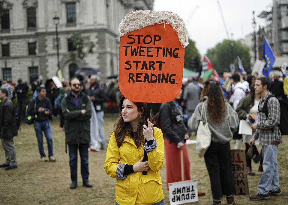 People hold placards with anti-Trump messages in central London, near the end of a protest against the state visit of President Donald Trump, Tuesday, June 4, 2019. Trump will turn from pageantry to policy Tuesday as he joins British Prime Minister Theresa May for a day of talks likely to highlight fresh uncertainty in the allies' storied relationship. (AP Photo/Matt Dunham)