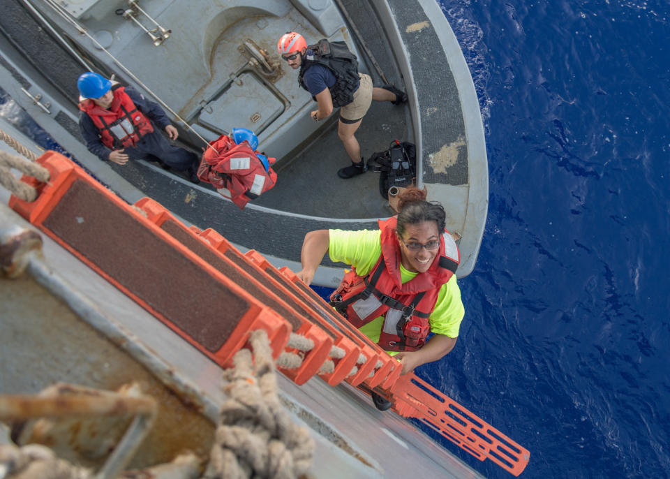 Tasha Fuiava, an American who had been sailing for five months on a damaged sailboat, climbs the ladder to board the amphibious dock landing ship USS Ashland. (Photo: Courtesy of US Navy)