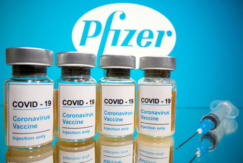 FILE PHOTO: Vials and medical syringe are seen in front of Pfizer logo in this illustration