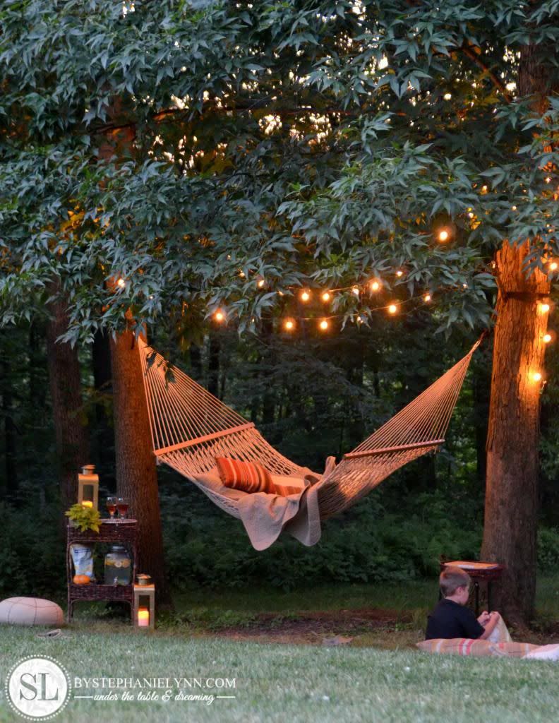 <p>Is there anything more soothing than a hammock gently swinging under string lights? This easy-to-pull-off setup is guaranteed to be your favorite spot to relax.</p><p><strong>Get the tutorial at <a href="http://www.bystephanielynn.com/2013/06/backyard-hammock.html" rel="nofollow noopener" target="_blank" data-ylk="slk:By Stephanie Lynn;elm:context_link;itc:0;sec:content-canvas" class="link ">By Stephanie Lynn</a>.</strong></p><p><strong><a class="link " href="https://www.amazon.com/Backyard-Hanging-Outdoor-Pergola-Deckyard/dp/B00RQHBZVS?tag=syn-yahoo-20&ascsubtag=%5Bartid%7C10050.g.3404%5Bsrc%7Cyahoo-us" rel="nofollow noopener" target="_blank" data-ylk="slk:SHOP STRING LIGHTS;elm:context_link;itc:0;sec:content-canvas">SHOP STRING LIGHTS</a><br></strong></p>