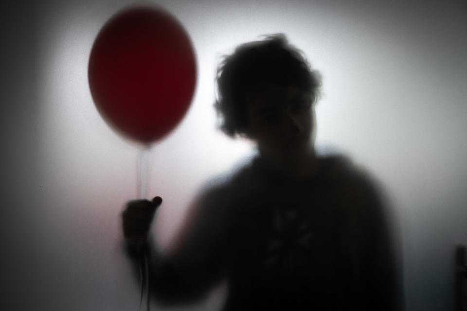 a spooky silhouette is holding a balloon