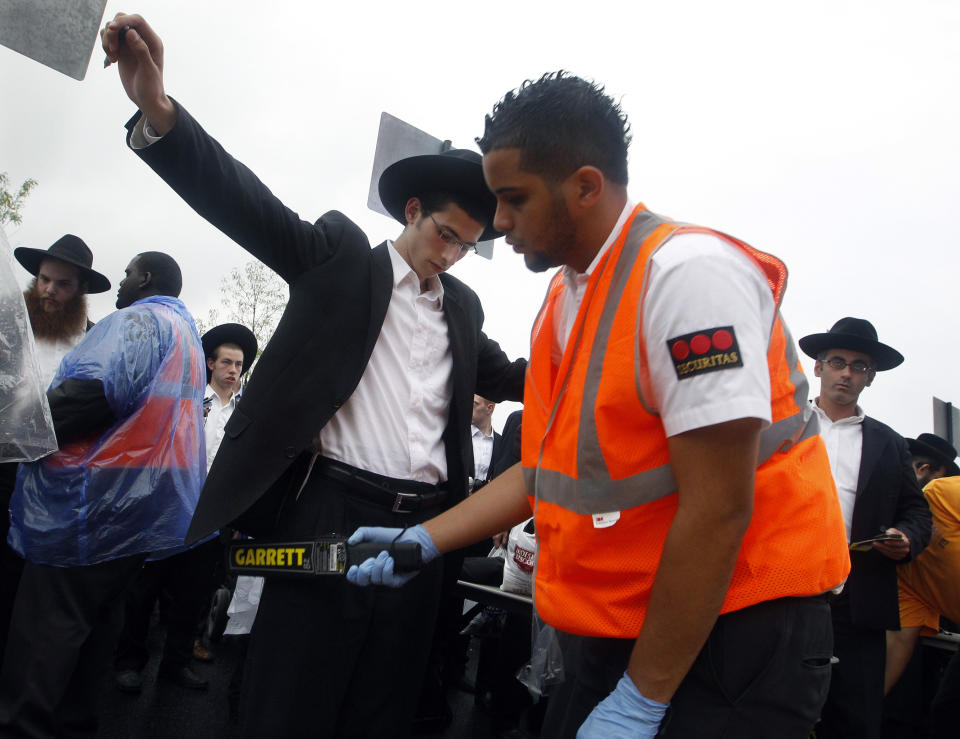 An Orthodox Jewish man is checked by security at MetLife stadium in East Rutherford, N.J, Wednesday, Aug. 1, 2012, as he arrives for the start of the celebration Siyum HaShas. The Siyum HaShas, marks the completion of the Daf Yomi, or daily reading and study of one page of the 2,711 page book. The cycle takes about 7½ years to finish.This is the 12th put on by Agudath Israel of America, an Orthodox Jewish organization based in New York. Organizers say this year's will be, by far, the largest one yet. More than 90,000 tickets have been sold, and faithful will gather at about 100 locations worldwide to watch the celebration. (AP Photo/Mel Evans)