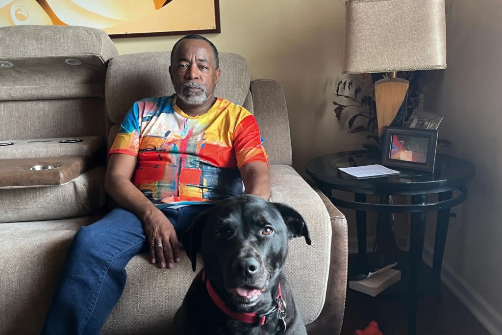 Malcolm Reid at home in Decatur, Georgia, with his dog, Sampson. Reid, who recently marked his 66th birthday and the anniversary of his HIV diagnosis, is part of a growing group of people 50 and older living with the virus. (Sam Whitehead/KFF Health News)