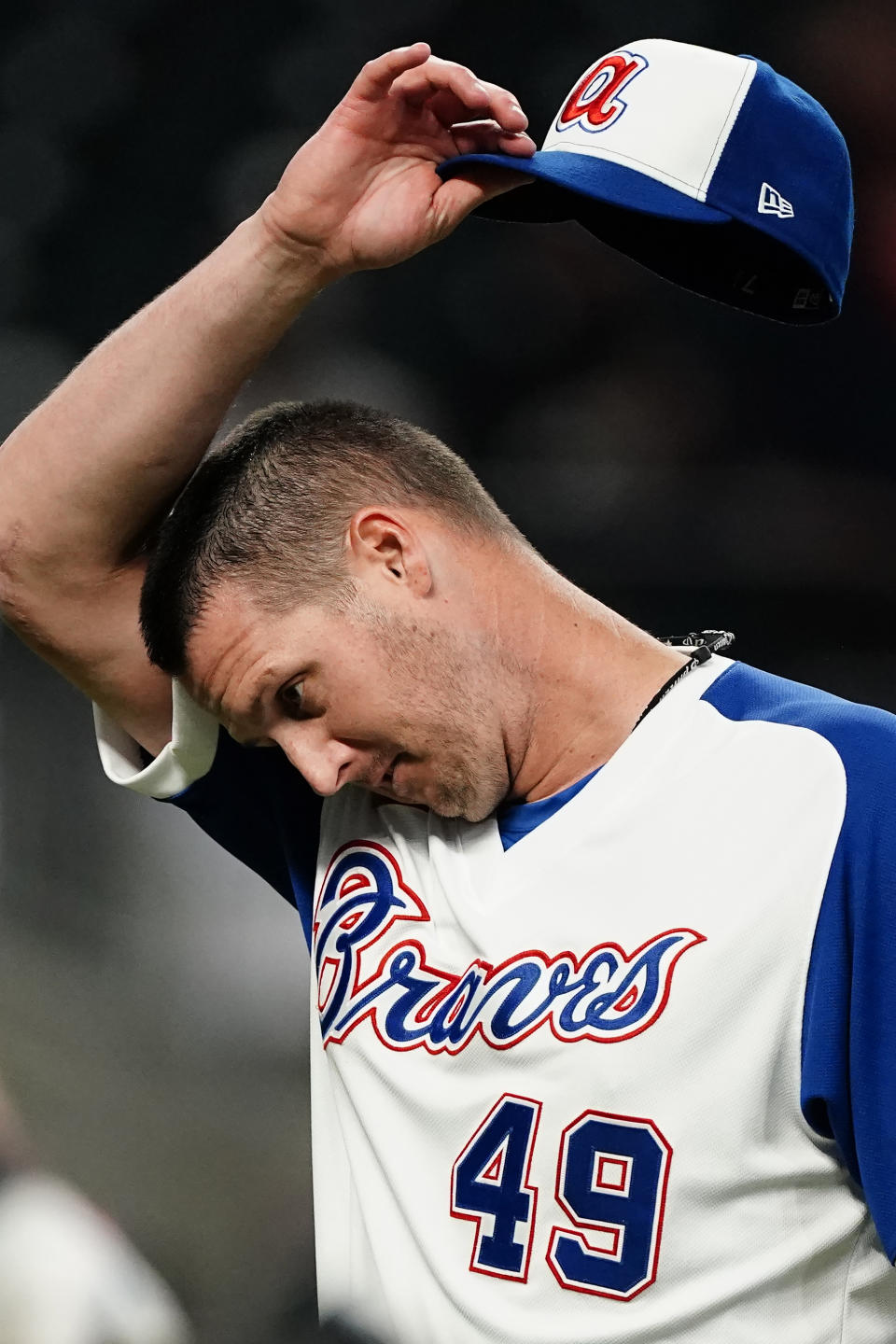 Atlanta Braves relief pitcher Nate Jones (49) wipes his face during a mound visit in the eighth inning of a baseball game against the Miami Marlins, Monday, April 12, 2021, in Atlanta. (AP Photo/John Bazemore)