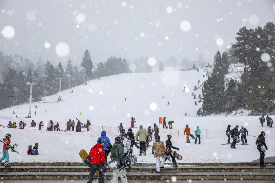 In this photo provided by Big Bear Mountain Resort, snowboarders head to the slopes at Big Bear Mountain Resort in Big Bear, Calif., on Monday, Dec. 23, 2019. Winter weather advisories are in effect for the interior mountains of Los Angeles and Ventura counties, where a foot more of snow is expected at elevations above 7,000 feet and lesser amounts down to 5,000 feet. (Jared Meyer/Big Bear Mountain Resort via AP)