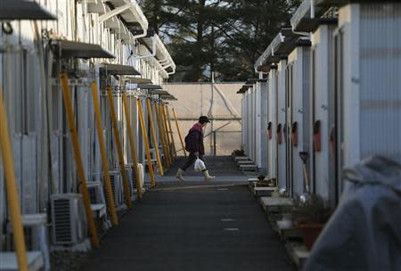 A woman walks in a temporary housing complex where evacuees from the Miyakoji area of Tamura are living, at Funahiki area in Tamura, Fukushima prefecture, April 1, 2014. REUTERS/Issei Kato