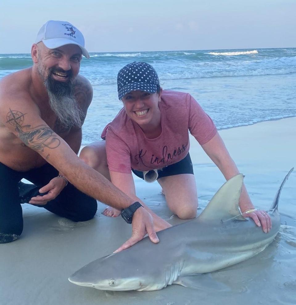 Dustin Smith (left), of NSB Shark Hunters, helped "Kate from Boston" land this 5-foot blacktip.