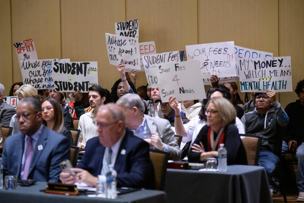 Students hold up signs in protest during the University of Houston’s board of regents meeting at the Hilton University of Houston Hotel on Wednesday, Feb. 21, 2024.