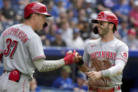 Cincinnati Reds' Tyler Naquin, right, celebrates with teammate Tyler Stephenson (37) after scoring on a double by teammate Joey Votto during the fourth inning of a baseball game against the Toronto Blue Jays in Toronto, Saturday, May 21, 2022. (Frank Gunn/The Canadian Press via AP)