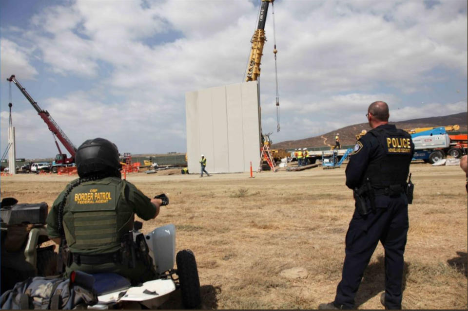 <p>A handout photo made available by U.S. Customs and Border Protection shows border patrol agents watching the construction of prototypes of the proposed border wall between the U.S. and Mexico near Otay Mesa, Calif., Oct. 3, 2017. (Photo: U.S. Customs and Border Protection/EPA-EFE/REX/Shutterstock) </p>