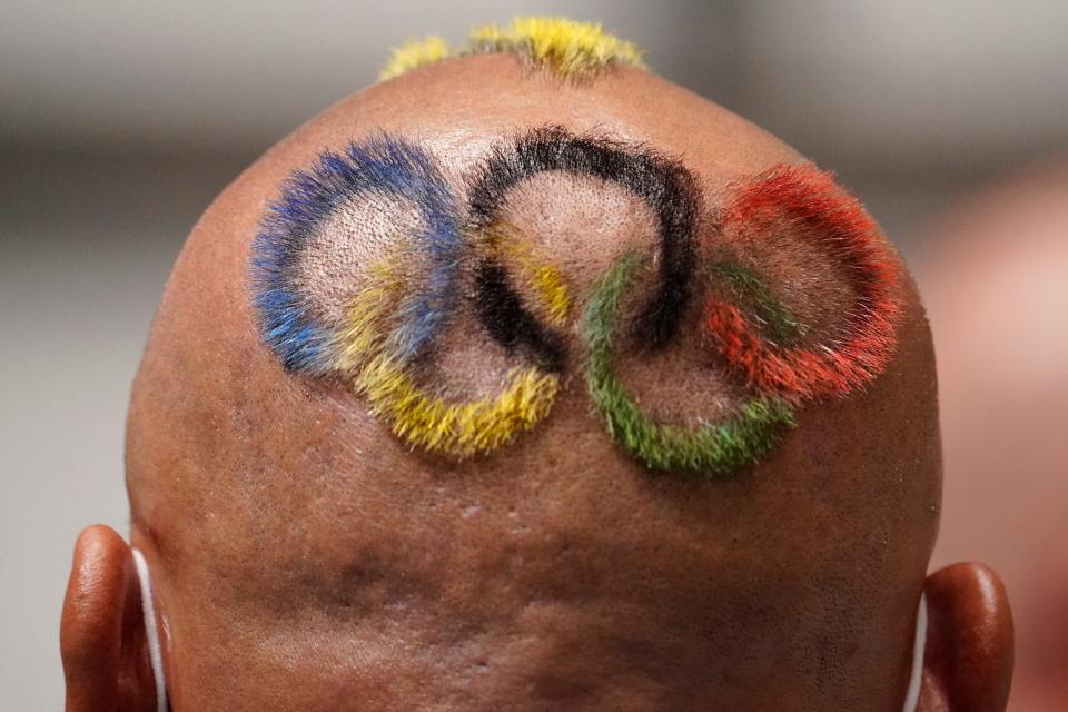 Undralbat Lkhagva, coach of Team Mongolia, who has his hair cut and dyed in the shape of the Olympic rings, watches the women's 25m pistol qualifications during the Tokyo 2020 Olympic Summer Games at Asaka Shooting Range on July 30, 2021. 