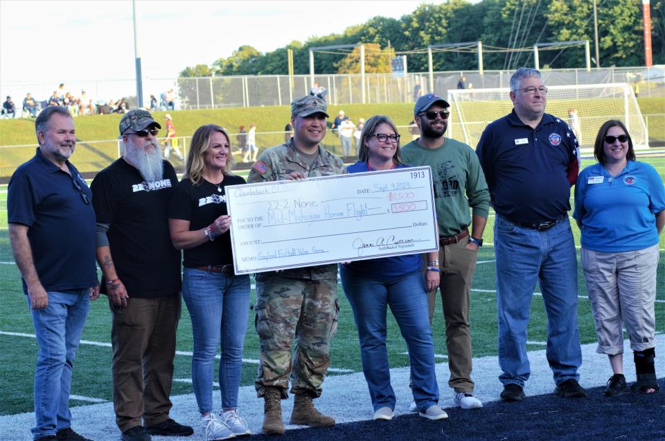 Staff Sergeant Ryan Kline (center left) and Jenni Caverson (center right) present a check for $3,500 to Mid-Michigan Honor Flight and $1,500 to members of the 22-2-None charity along with state rep. Ken Borton (far left) on Saturday, Sept. 9 at Gaylord's third annual Valor Game.