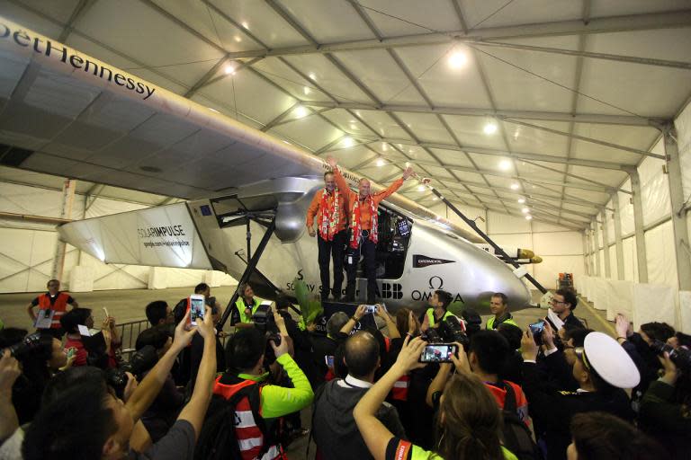 Solar Impulse 2 pilots Andre Borschberg (L) and Bertrand Piccard wave to the media after landing in Chongqing airport at 1:35 am (17:35 GMT Monday) after a 20-and-a-half hour flight from Myanmar, on March 31, 2015