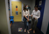 Middle school student Elise Robinson, left, waits with her mother, Anya Robinson, for her first coronavirus vaccination on Wednesday, May 12, 2021, in Decatur, Ga. Hundreds of children, ages 12 to 15, received the Pfizer vaccine at the DeKalb Pediatric Center, just days after it was approved for use within their age group. (AP Photo/Ron Harris)