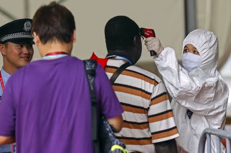 People have their temperature taken at the entrance of the Canton Fair in Guangzhou, Guangdong province, October 26, 2014. REUTERS/Alex Lee