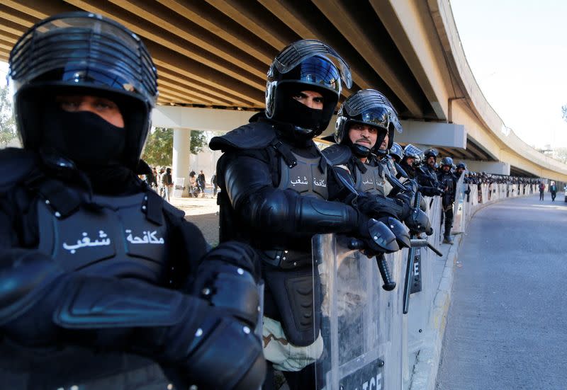 Iraqi riot police stand by as supporters of Iraqi Shiite parties disputing the vote results gather before the final verdict ratifying election results is issued by Iraq's Supreme Court, in Baghdad