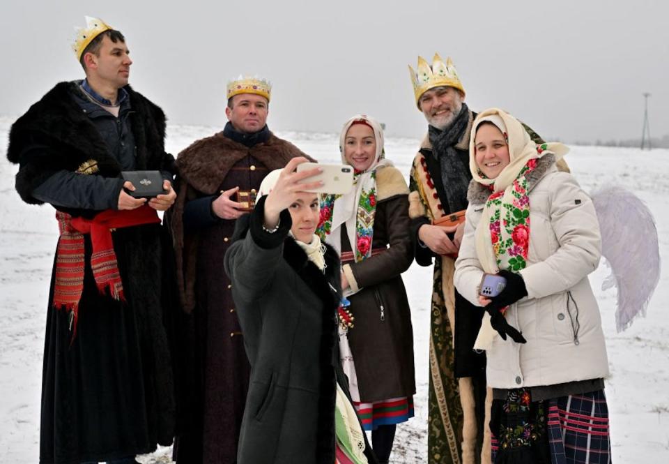 People perform and sing carols near Kyiv during the celebration of Malanka in January 2023. <a href="https://www.gettyimages.com/detail/news-photo/people-take-a-selfie-as-costumed-people-perform-and-sing-news-photo/1246226899?adppopup=true" rel="nofollow noopener" target="_blank" data-ylk="slk:Sergei Supinsky/AFP via Getty Images;elm:context_link;itc:0;sec:content-canvas" class="link ">Sergei Supinsky/AFP via Getty Images</a>
