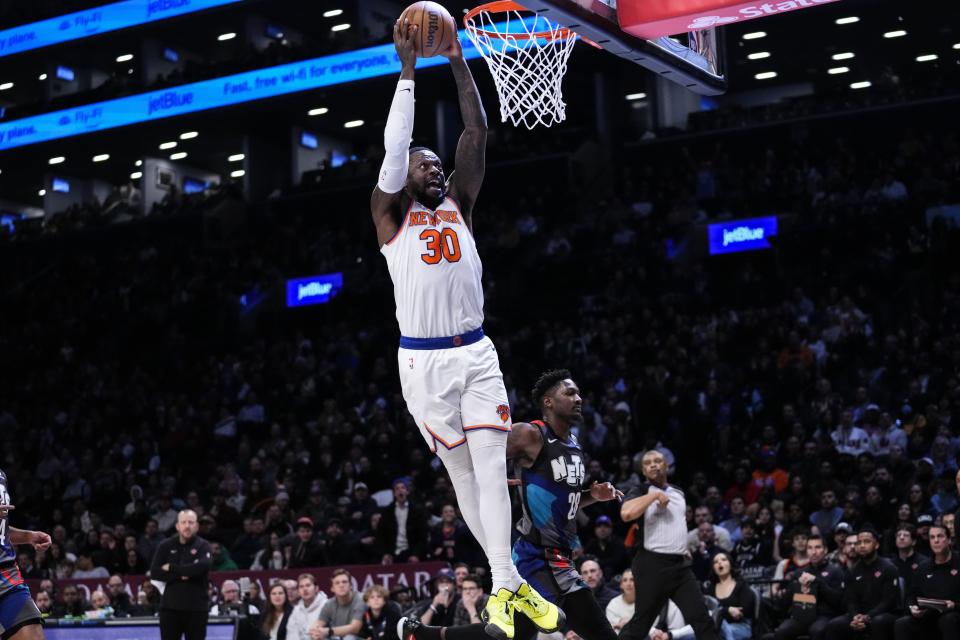 New York Knicks' Julius Randle (30) dunks the ball in front of Brooklyn Nets' Dorian Finney-Smith (28) during the first half of an NBA basketball game Wednesday, Dec. 20, 2023, in New York. (AP Photo/Frank Franklin II)
