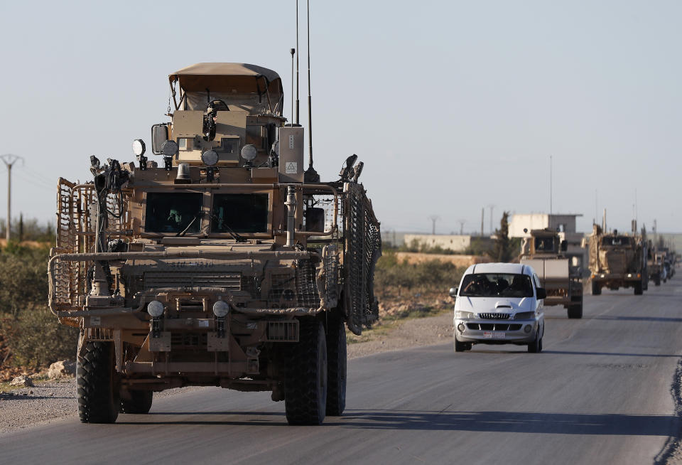 FILE - In this Saturday, March 31, 2018 file photo, a convoy of U.S. troops drive along a road leading to the front line with Turkish-backed fighters, in Manbij, north Syria. An American military official said Friday, Jan. 11, 2019 that the U.S.-led military coalition has begun the process of withdrawing troops from Syria. (AP Photo/Hussein Malla, File)