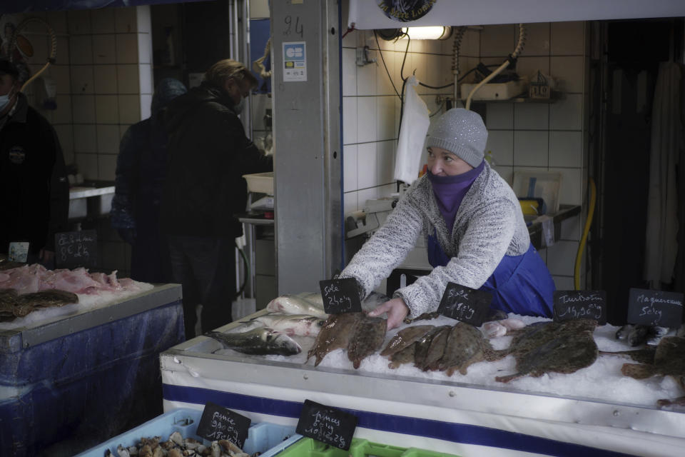 FILE - In this Thursday, Dec. 10, 2020 file photo, a fish seller arranges her stall at the market of the port of Boulogne-sur-Mer, northern France. The European Council adopted Tuesday, Sept. 28, 2021 a euro 5 billion (US dollar 5.8 billion) reserve aimed at helping businesses tackle the short-term negative effects of Brexit. Britain's departure has affected many parts of the EU economy, with the fishing sector particularly at risk. According to the European Commission, EU fisheries face a 25 percent reduction of their catch value in UK waters. (AP Photo/Thibault Camus, File)