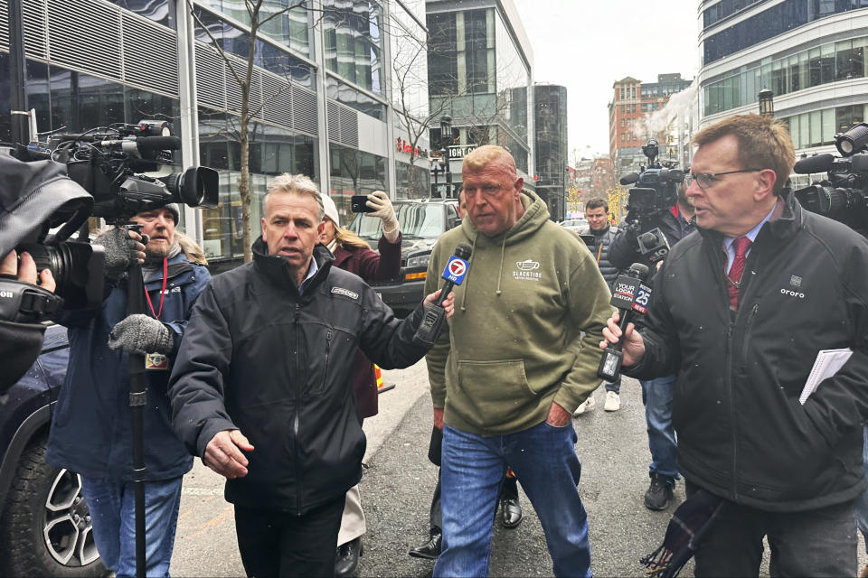 Massachusetts State Police Sgt. Gary Cederquist, center, leaves federal court. Tuesday, Jan 30, 2024, in Boston. Cederquist, 58, of Stoughton, and five others have been charged Tuesday in a scheme to allegedly take bribes including a new snowblower and driveway in exchange for giving passing scores on commercial driving tests, the U.S. attorney’s office said Tuesday. (AP Photo/Michael Casey)