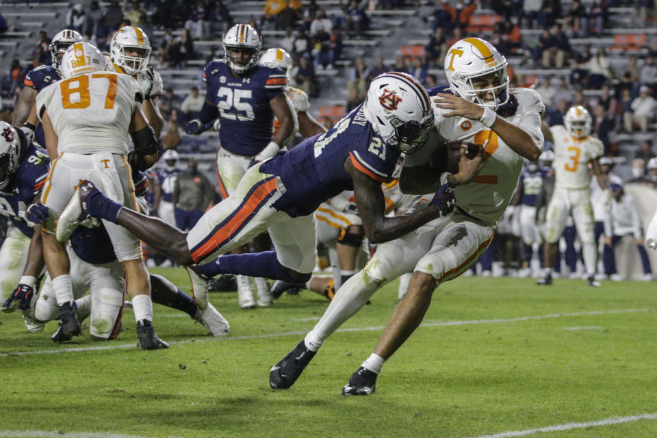 Tennessee quarterback Jarrett Guarantano (2) caries the ball in for a touchdown as Auburn defensive back Smoke Monday (21) tries to stop him during the first half of an NCAA college football game Saturday, Nov. 21, 2020, in Auburn, Ala. (AP Photo/Butch Dill)