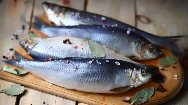 Whole herrings on a cutting board