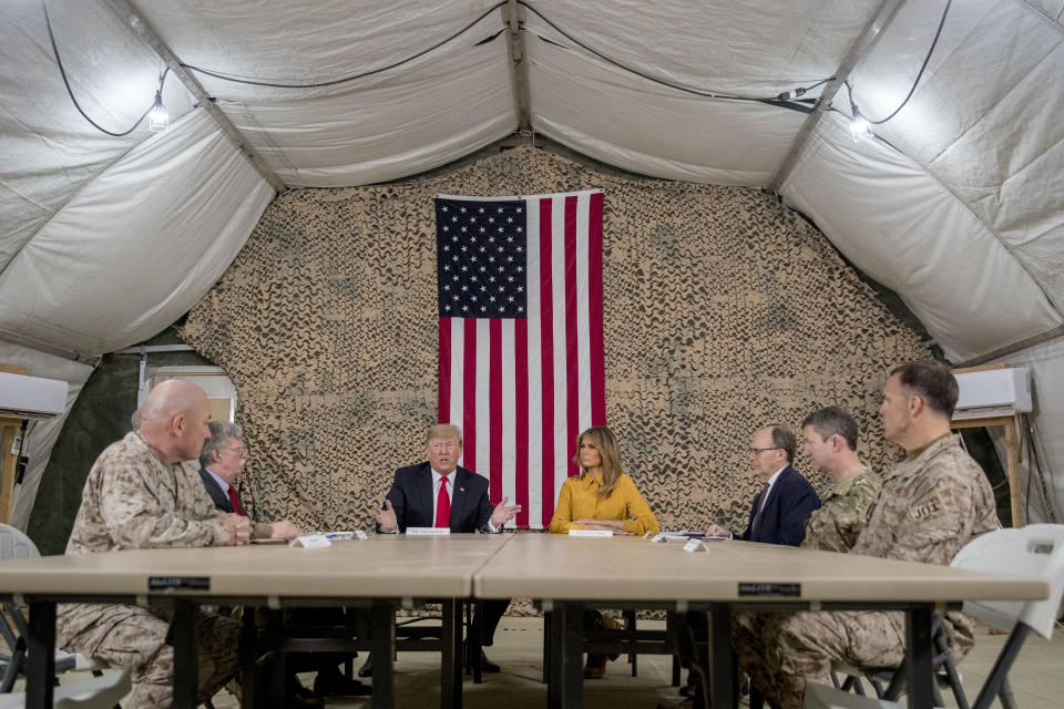 President Donald Trump, accompanied by National Security Adviser John Bolton, third from left, first lady Melania Trump, fourth from right, US Ambassador to Iraq Doug Silliman, third from right, and senior military leadership, speaks to members of the media at Al Asad Air Base, Iraq, Wednesday, Dec. 26, 2018. (Photo: Andrew Harnik/AP)