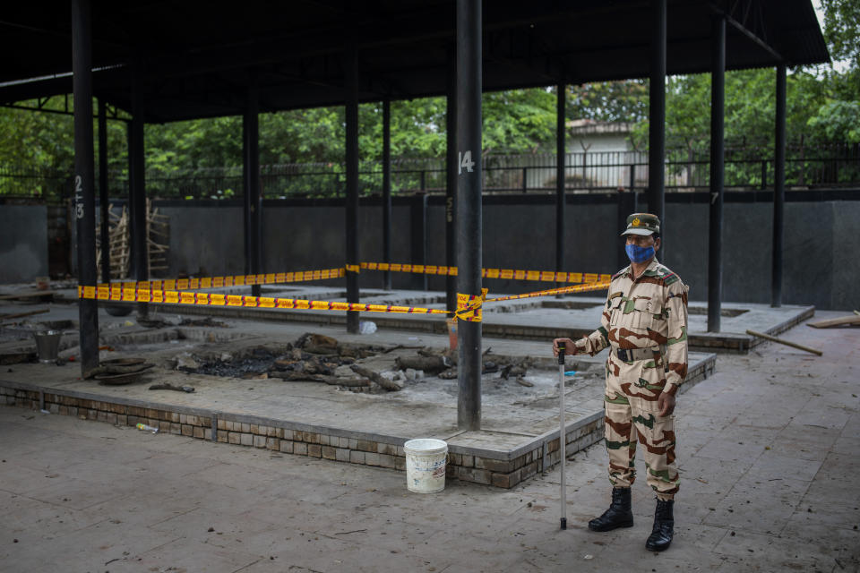 An Indian paramilitary soldier stands guard near a pyre inside a crematorium where a 9-year-old girl from the lowest rung of India's caste system was cremated, earlier this week, in New Delhi, India, Thursday, Aug. 5, 2021. Angry villagers held a protest saying the girl was raped and killed. (AP Photo/Altaf Qadri)