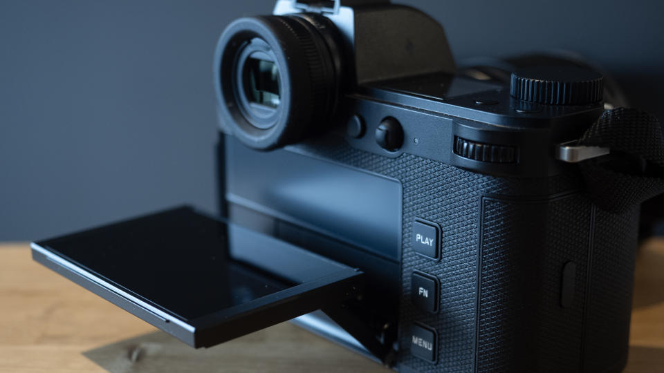 Leica SL3 camera on a wooden surface against a blue background