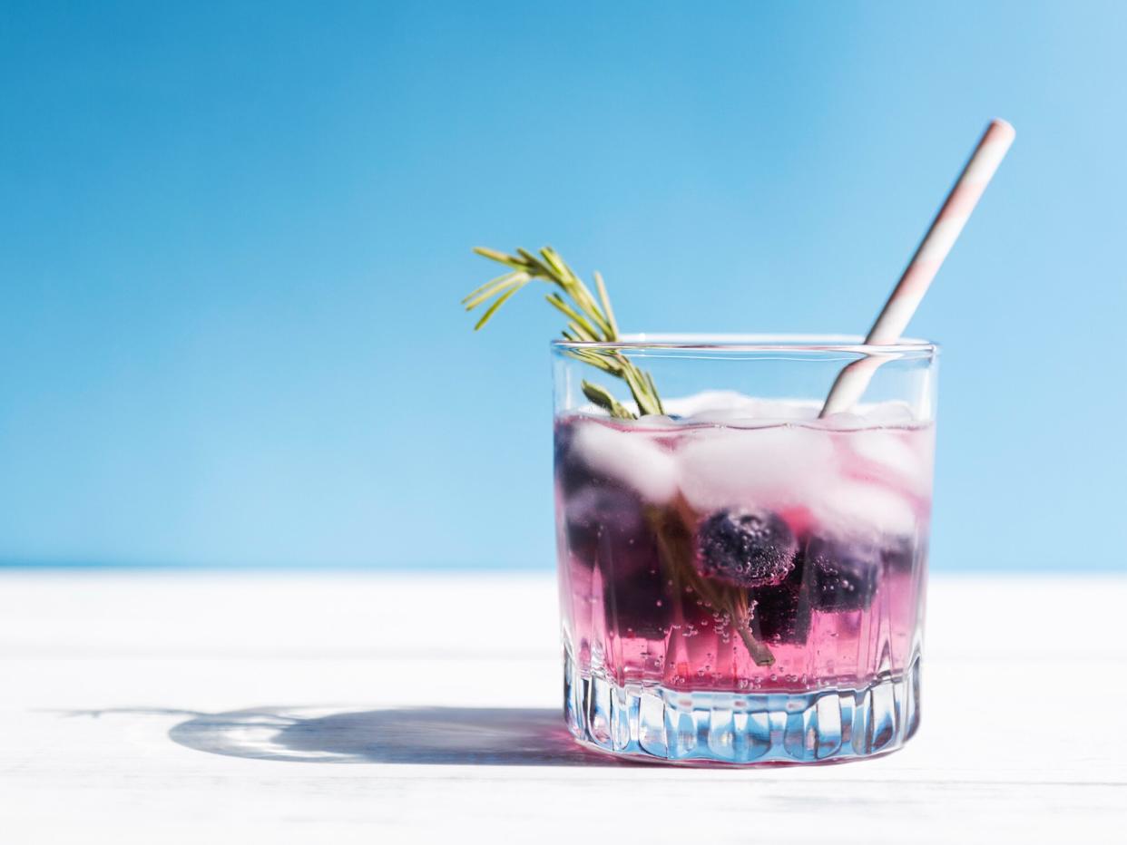 soda cocktail with fresh berries and a straw