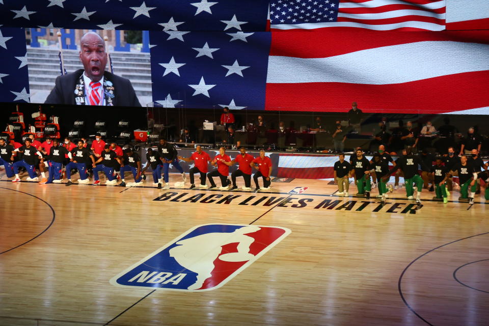 Philadelphia 76ers and Boston Celtics players kneel for the national anthem before Game 4 of an NBA basketball first-round playoff series, Sunday, Aug. 23, 2020, in Lake Buena Vista, Fla. (Kim Klement/Pool Photo via AP)