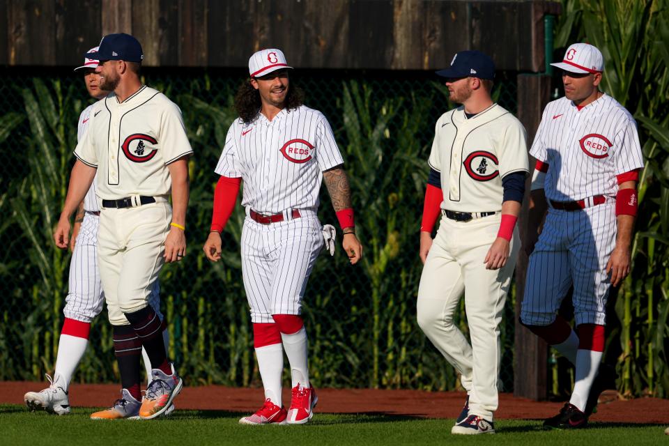Cincinnati Reds second baseman Jonathan India (6) smiles toward Chicago Cubs left fielder Ian Happ (8) as they enter right field from the corn fields, Thursday, Aug. 11, 2022, at the MLB Field of Dreams stadium in Dyersville, Iowa. 