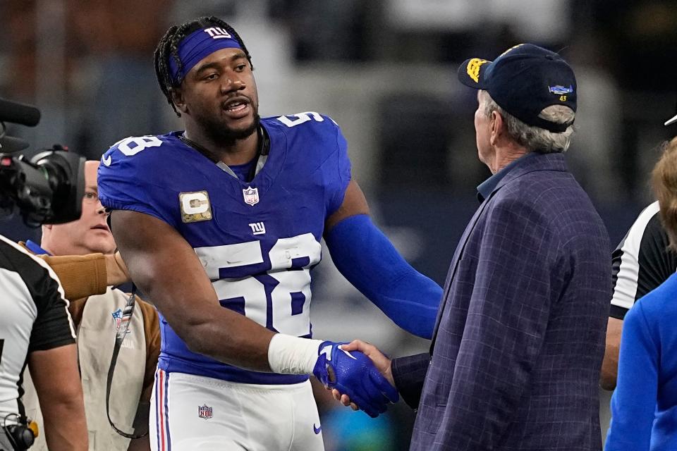 New York Giants linebacker Bobby Okereke (58) shakes hands with former President George W. Bush, right, before an NFL football game between the New York Giants and the Dallas Cowboys, Sunday, Nov. 12, 2023, in Arlington, Texas. (AP Photo/Tony Gutierrez)