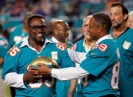 Dec 14, 2015; Miami Gardens, FL, USA; Miami former wide receiver Mark Duper (85) gets his commemorative ball from former wide receiver Nat Moore (89) during a halftime ceremony at Sun Life Stadium. Mandatory Credit: Andrew Innerarity-USA TODAY Sports