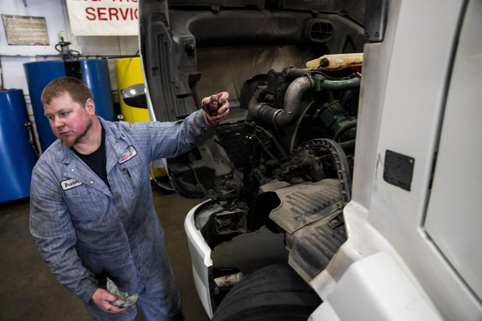 Big Truck Service owner Brandon Bauer, who says he has seen business drop by a third since the indefinite closure of the nearby Fishing Wars Memorial Bridge, does an oil change on a truck Tuesday, March 26, 2024, in Fife, Wash. The bridge has been closed since October 2023 after the Federal Highway Administration raised safety concerns, causing nearby business owners to notice a decrease in customers as drivers bypass their street. (AP Photo/Lindsey Wasson)